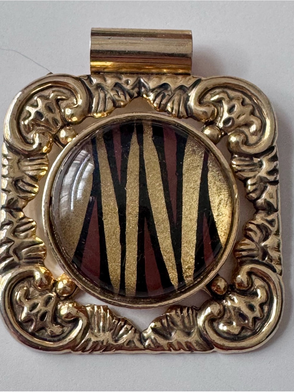 Gold tone pendant with brown center